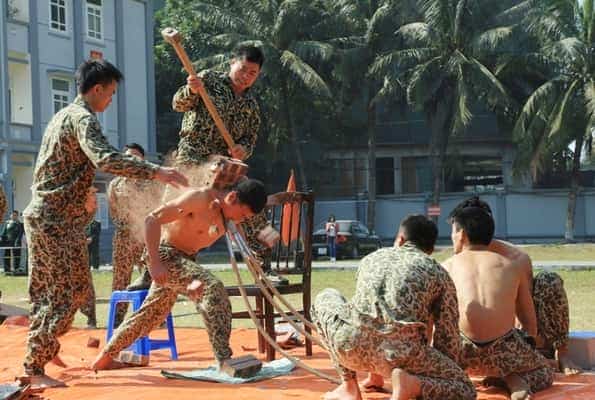 <span style="color: black;"><em><span style="color: black;"><em><span style="color: black;"><em><span style="color: black;">Chiến sĩ đặc công nhảy từ trên cao xuống mảnh chai, dùng yếu hầu đẩy cong 3 cây thương nhọn, vai kê gạch để đồng đội công phá.</span>